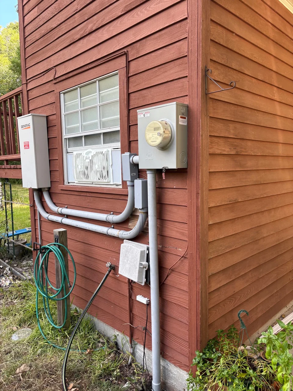 Generator transfer switch enclosure with conduit beside the utility meter