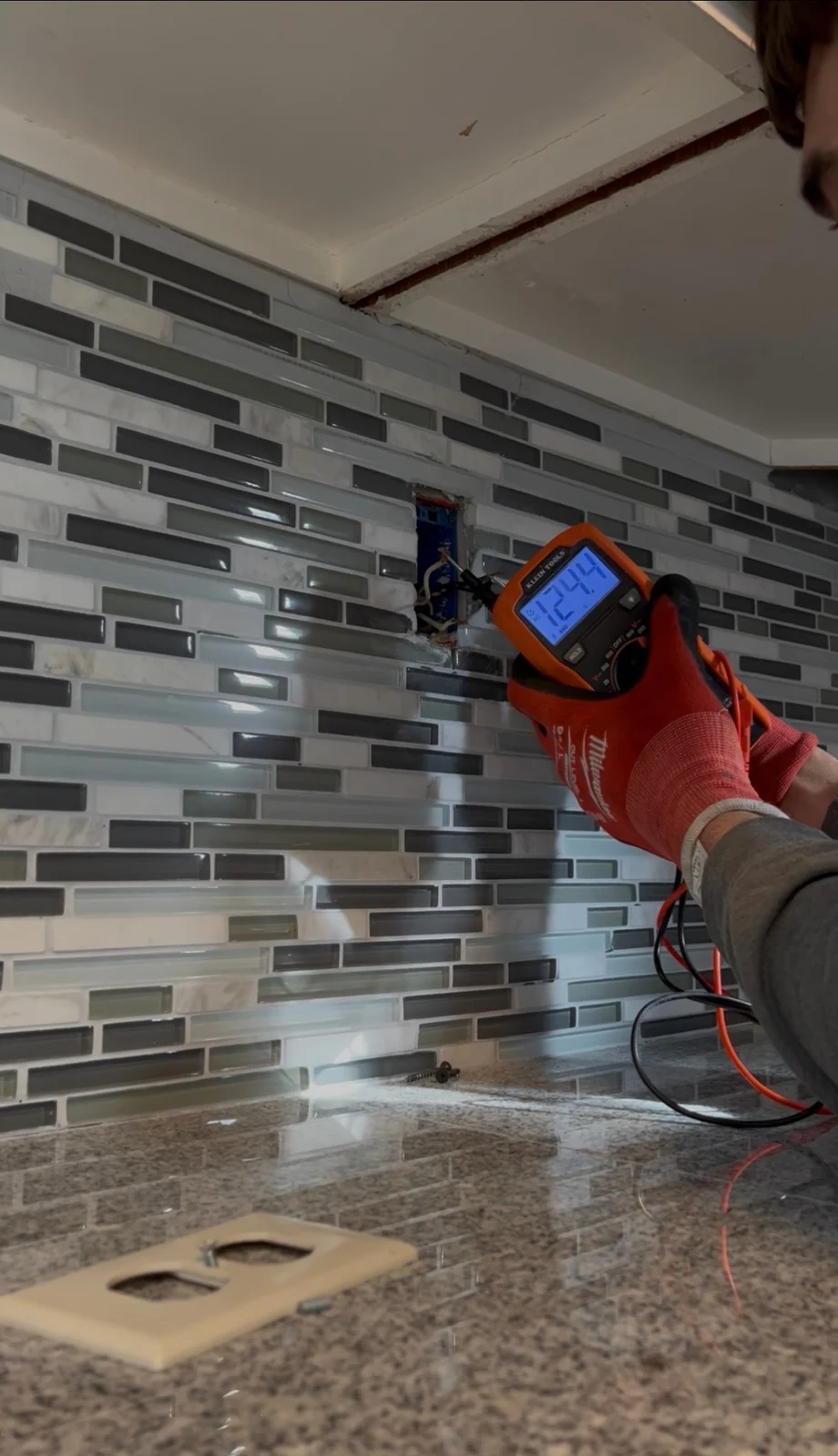 Voltage testing at a kitchen electrical box with a handheld meter