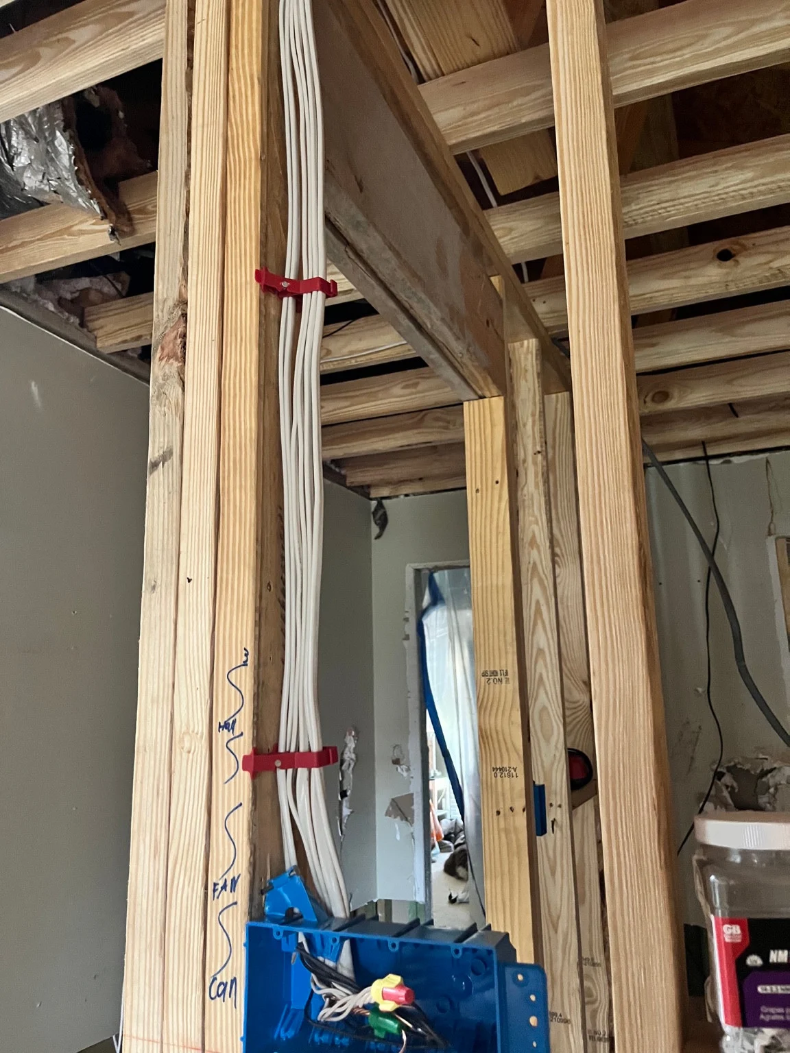 Electrical cables and a device box in exposed residential-addition framing