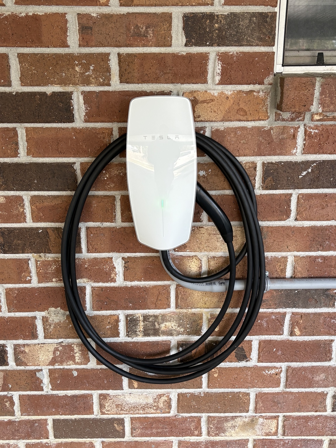 Tesla Wall Connector installed on a brick exterior wall by MNM Electrical Solutions